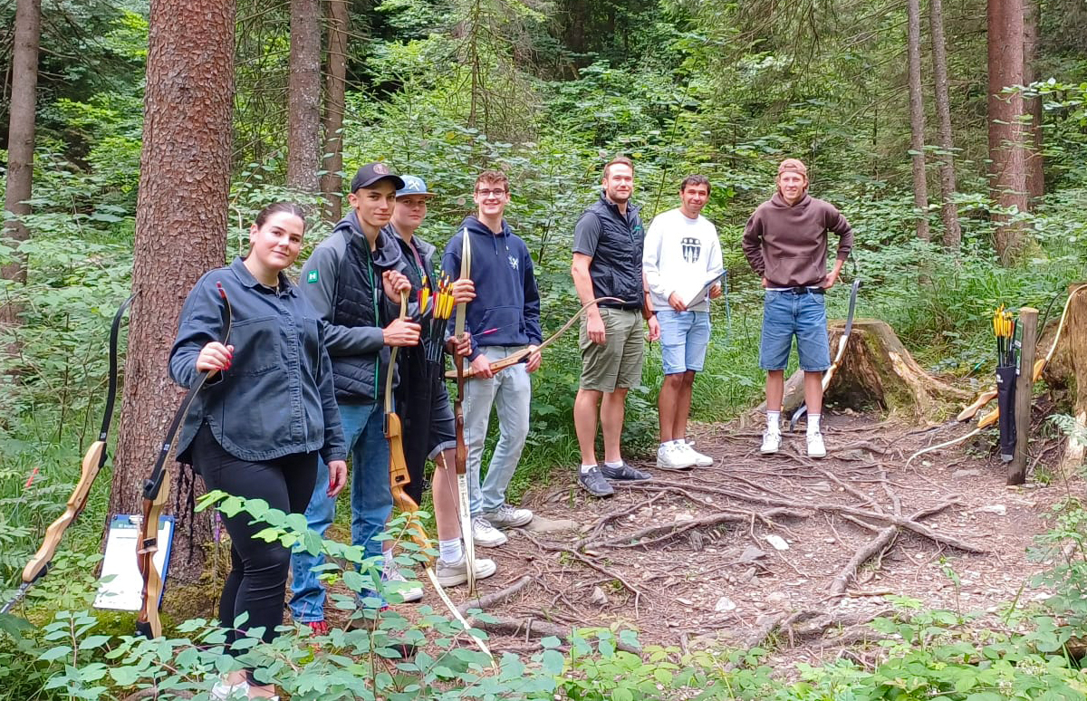Gruppenfoto von 6 Azubis und ihrem Betreuer in der Höllschlucht Pfronten beim Bogenschießen